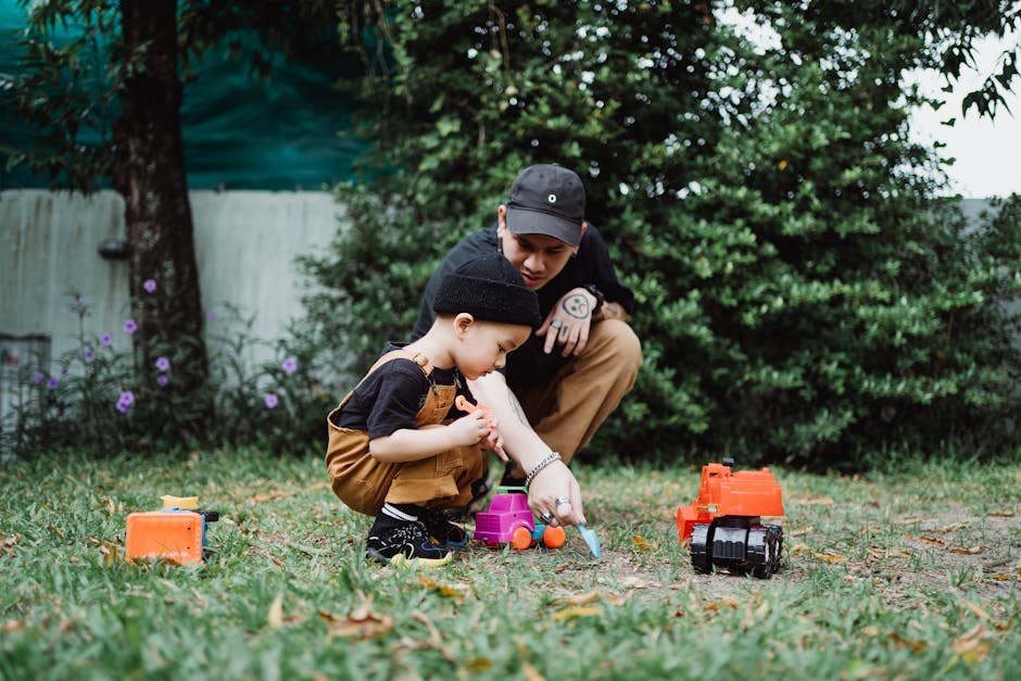 Father and son enjoying quality time playing with toys in a garden setting.